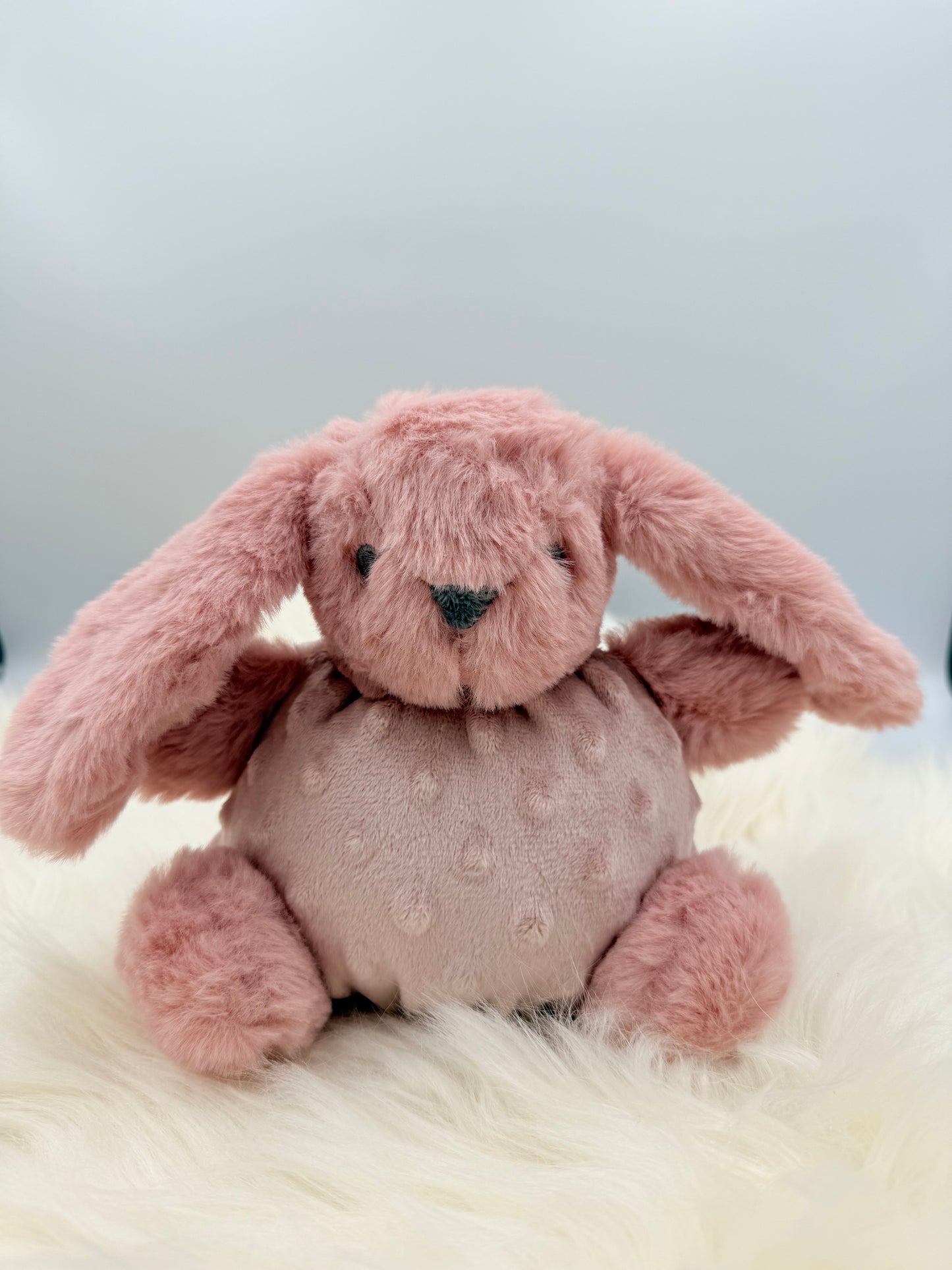 Zittend knuffel konijn met rammelaar roze